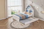 Children's house-shaped bed with shelves in a room with polka dot wallpaper.